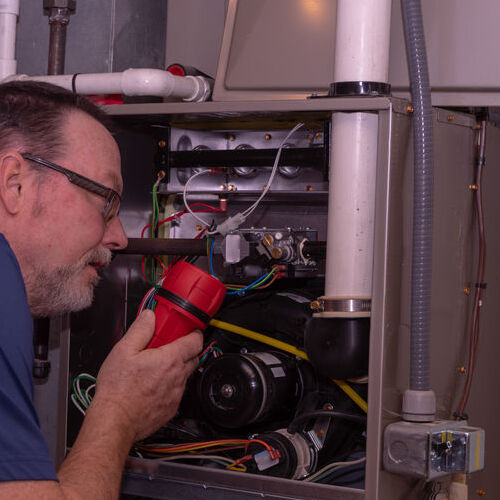 An HVAC Technician Inspects a Furnace