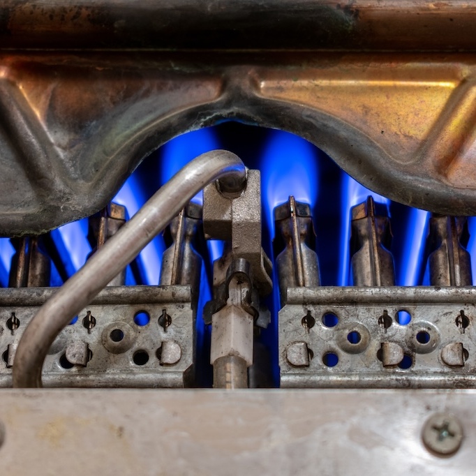 The blue-purple flames of a gas furnace are pictured.